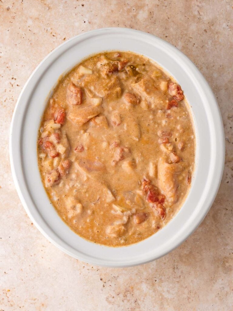 Uncooked coconut chicken curry mixture in the slow cooker before the spices blend and thicken.