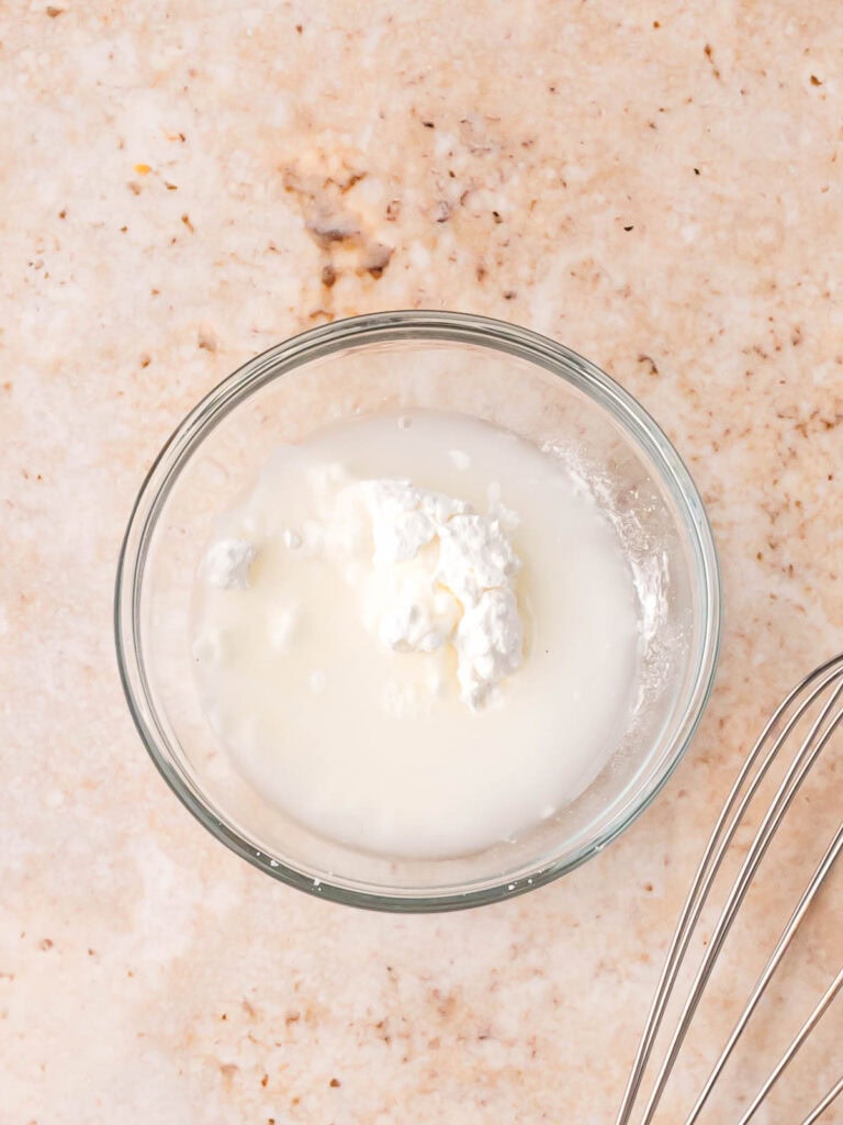 Small bowl with cornstarch slurry used to thicken the coconut chicken curry.