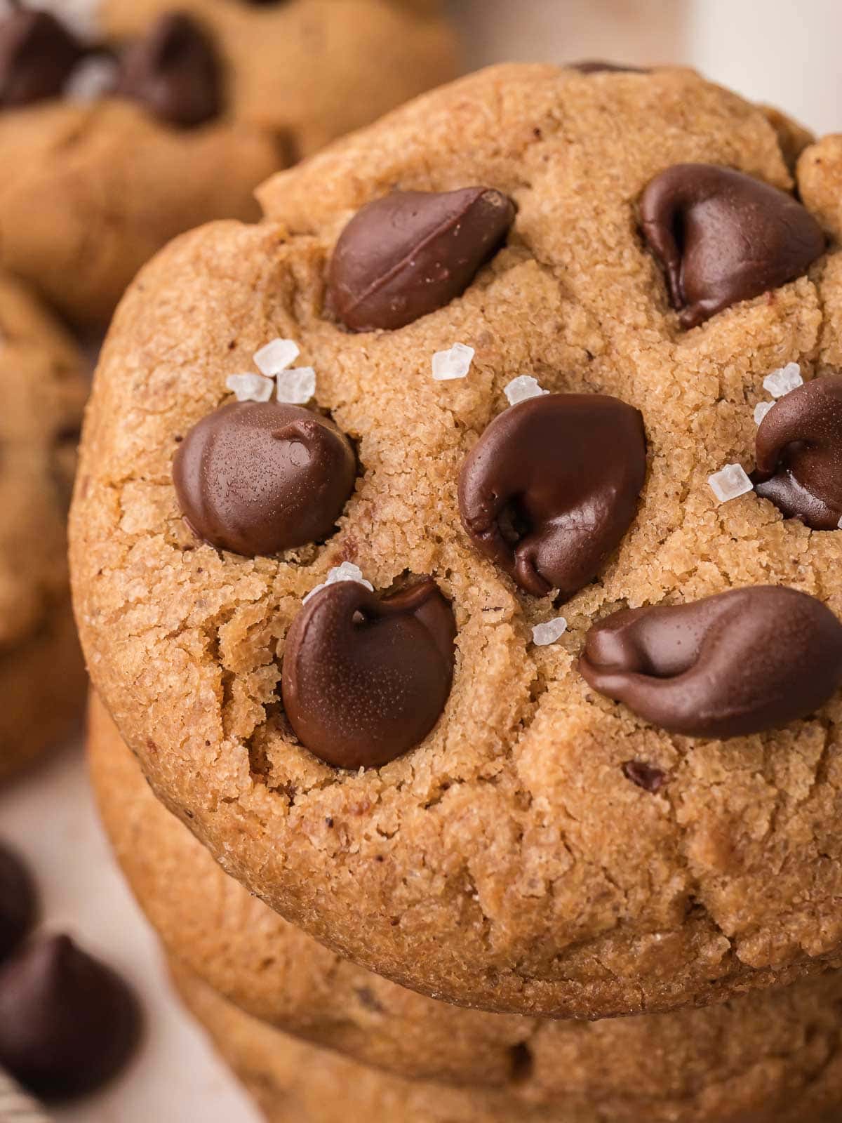Close-up of brown butter chocolate chip cookie topped with melted chocolate chips and flaky sea salt.
