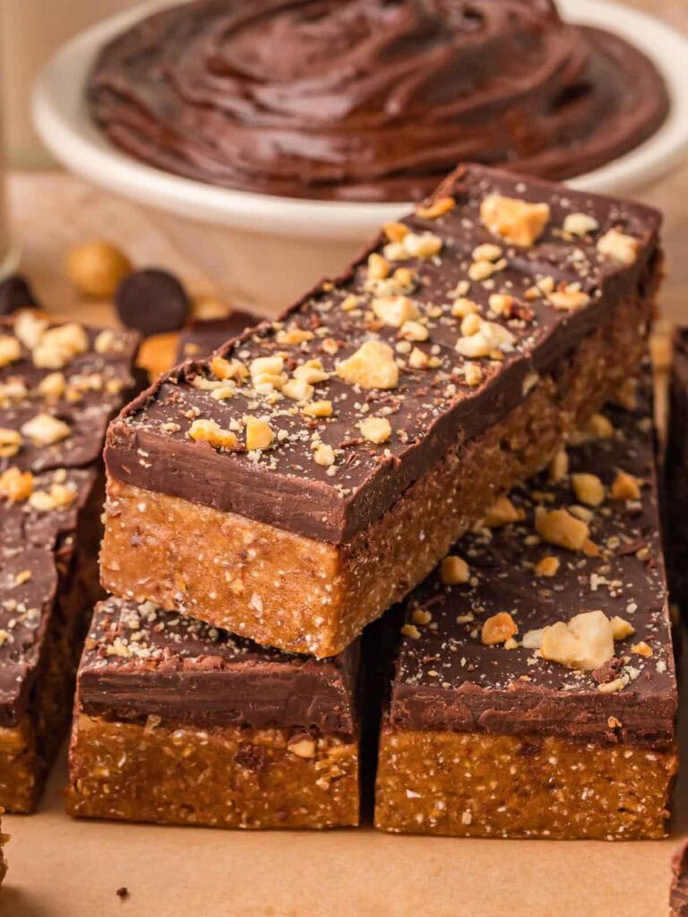 Stacked chocolate peanut butter protein bars showing the soft peanut butter base and smooth chocolate topping.