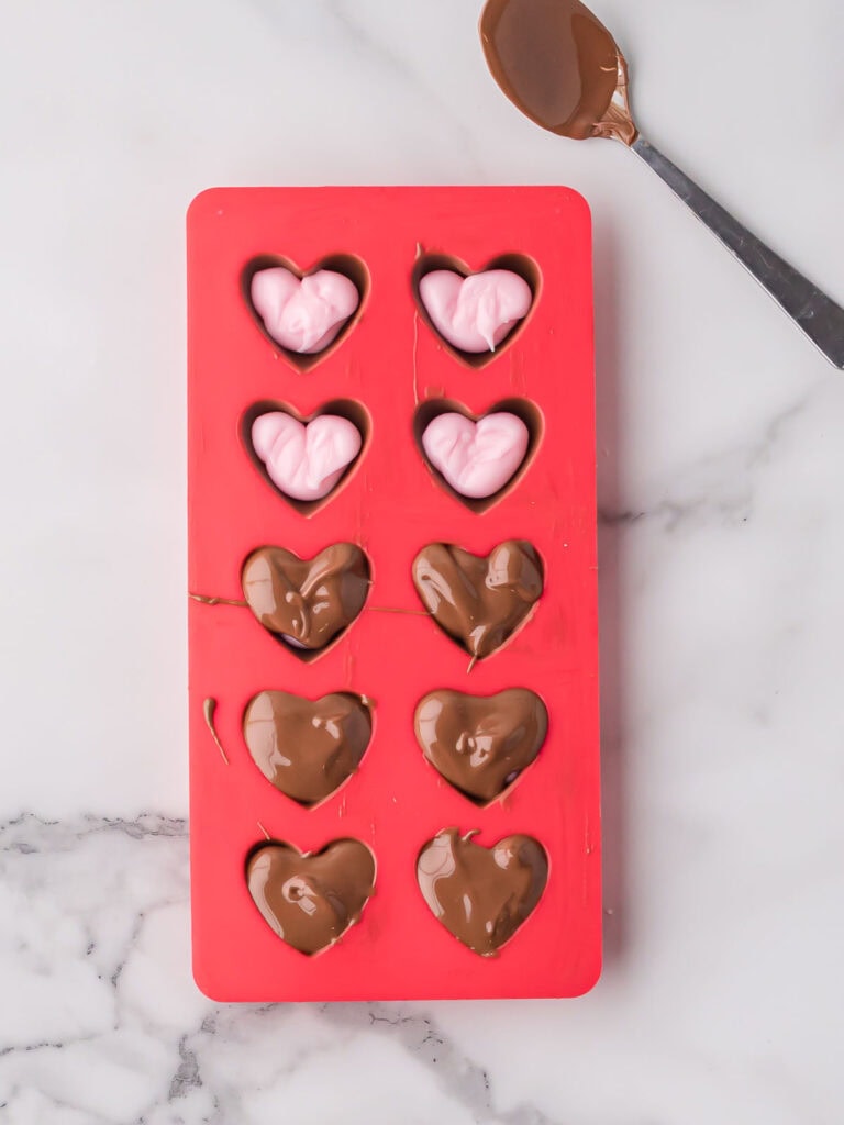 Melted chocolate spooned over fondant filling to seal homemade chocolates.