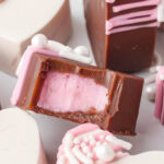 The Inside of a homemade filled chocolate heart showing pink fondant cream filling inside.