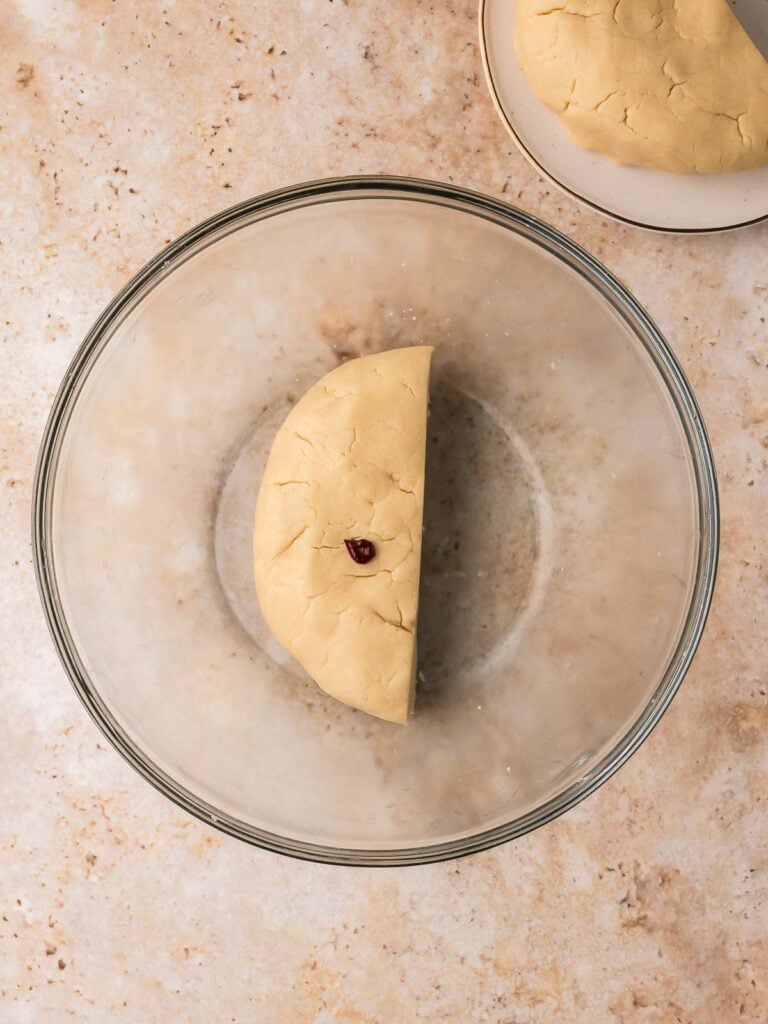 Cookie dough divided in half with some red food coloring.