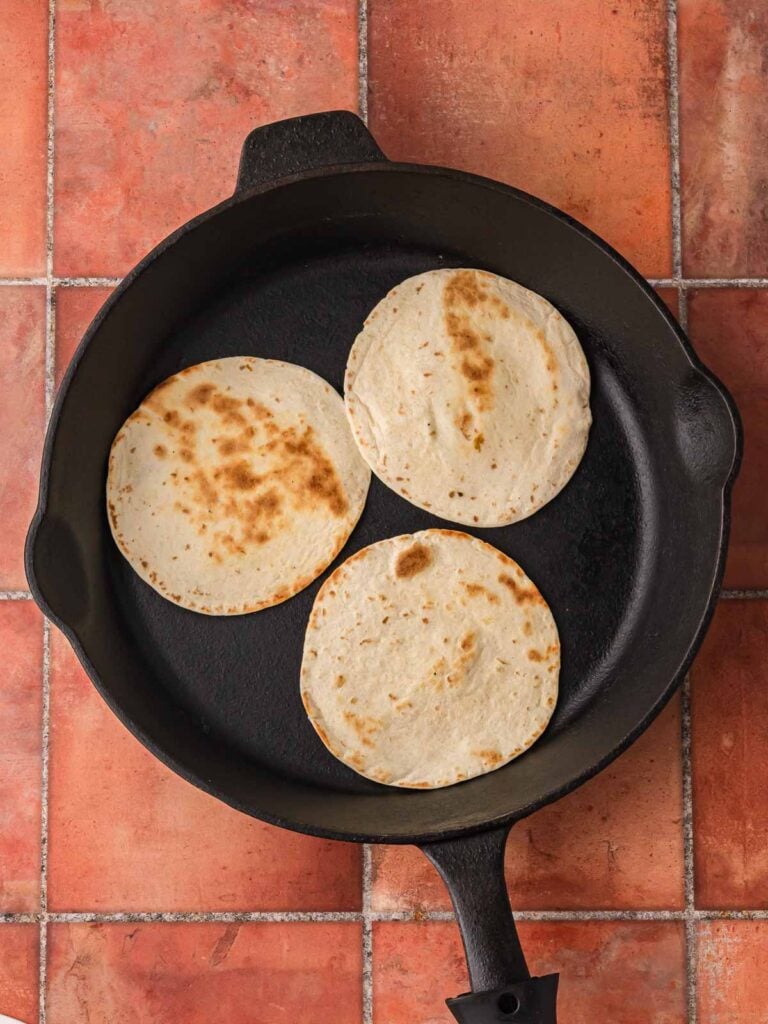 Warming flour tortillas in a cast iron skillet.
