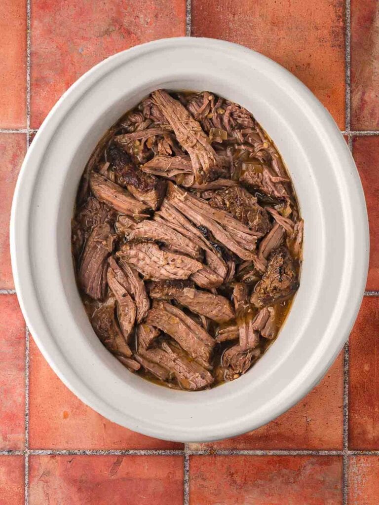 Slow cooker shredded beef ready to be used for tacos.