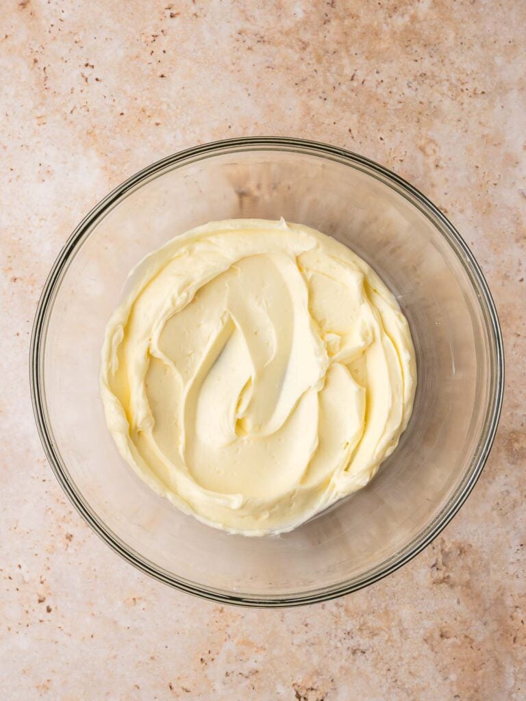 Softened butter creamed in a glass bowl for heart jam cookie dough.