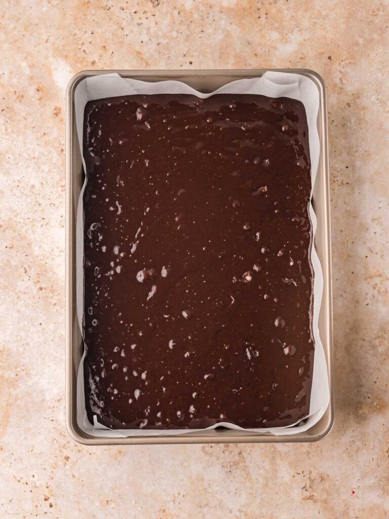 Brownie batter in a 9x3 pan ready to be baked.