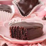 Chocolate heart brownie cut in half showing a fudgy brownie center with chocolate coating.