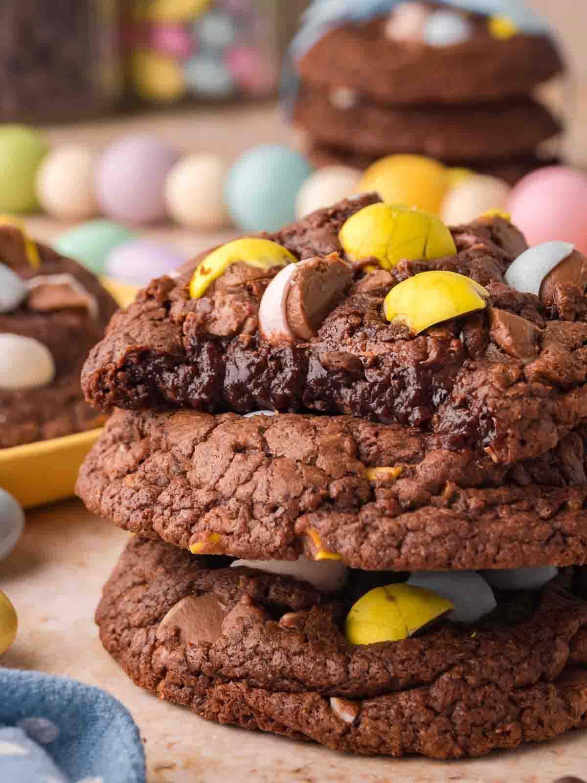 Stack of Cadbury Egg brownie cookies showing soft, fudgy centers and melted chocolate pieces.