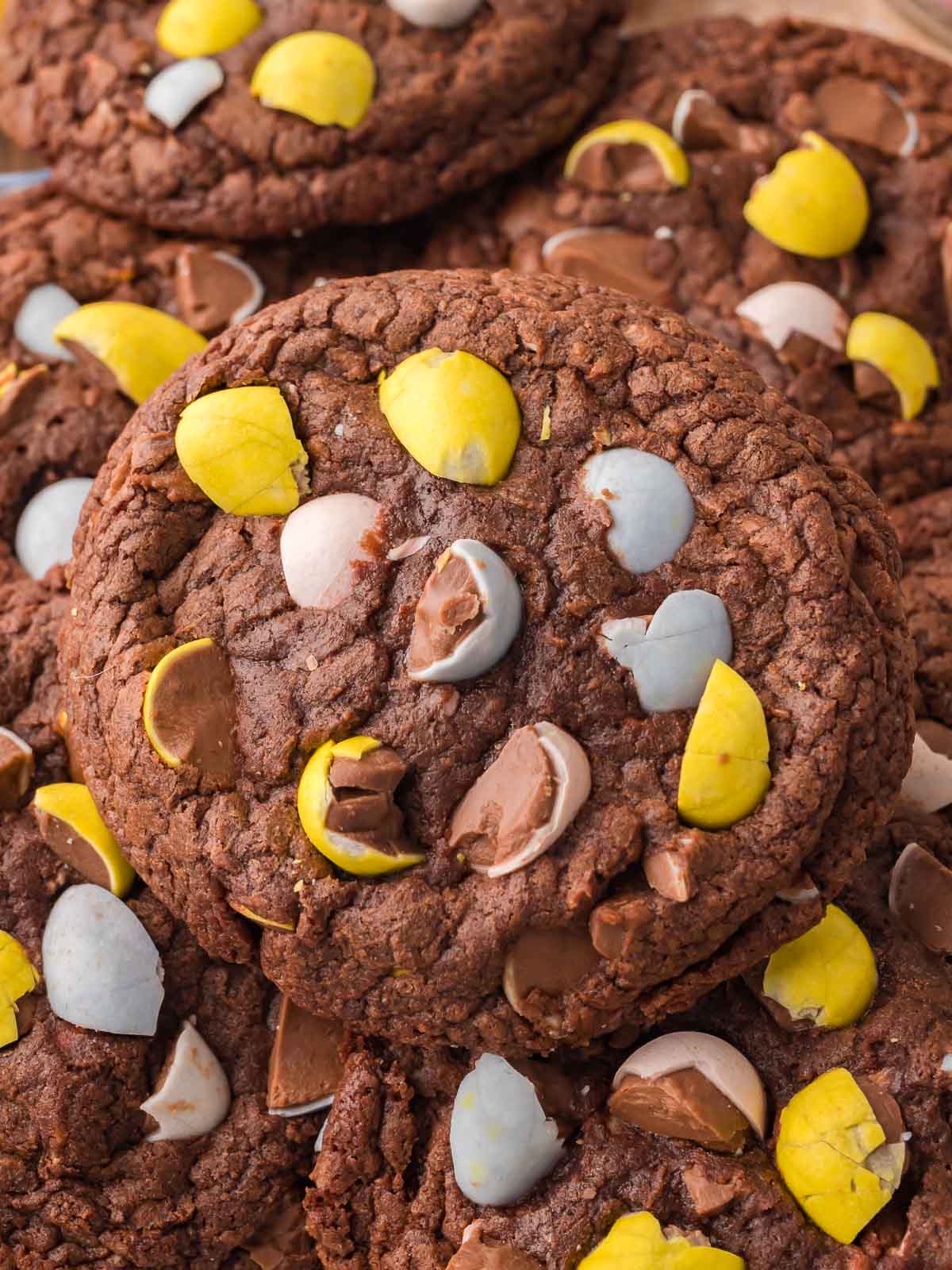 Close up of Cadbury Egg brownie cookies topped with chopped mini eggs and chocolate chunks.