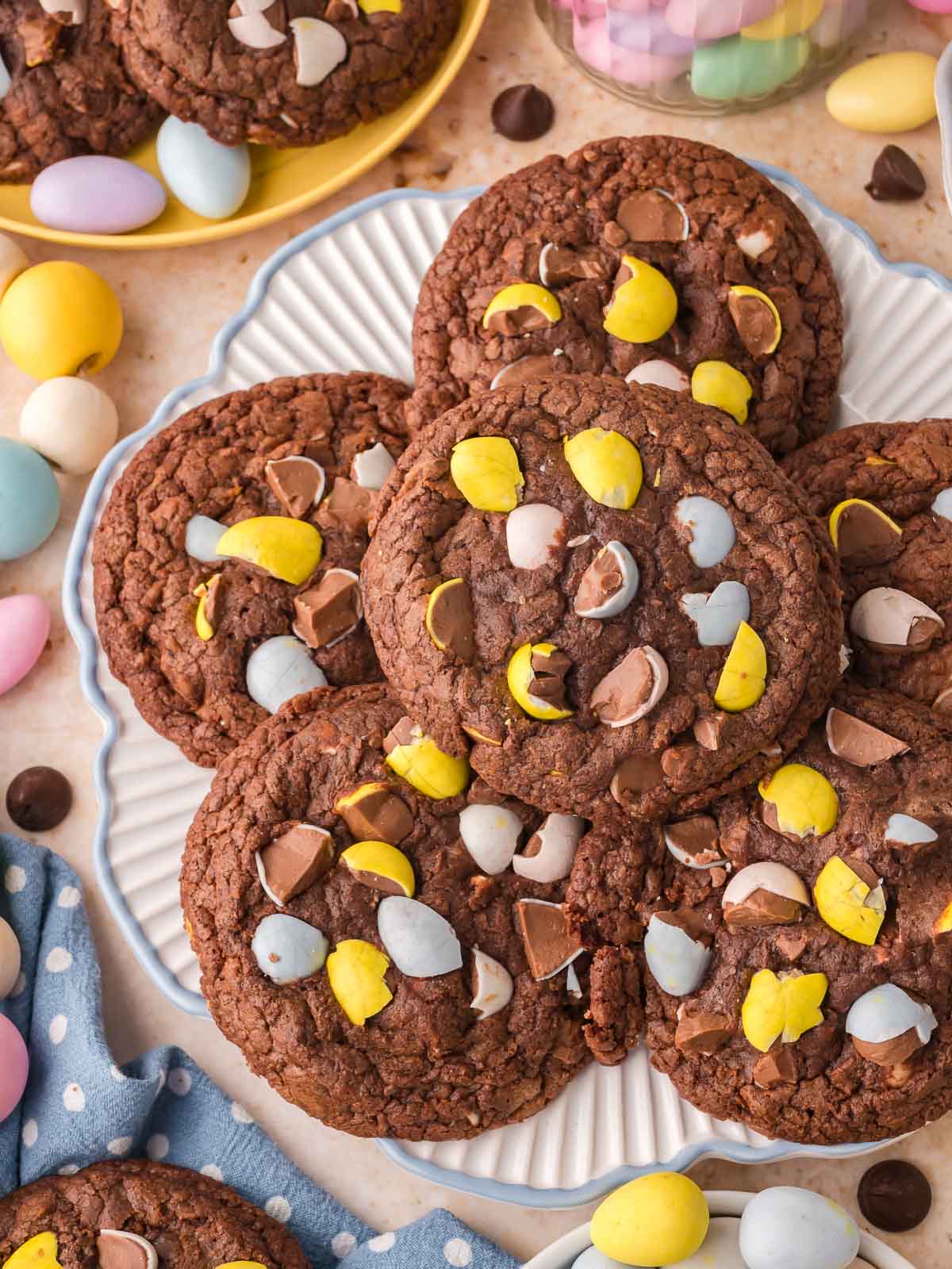 Plate of Cadbury Egg brownie cookies with chocolate chunks and colorful mini eggs.