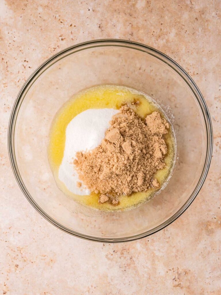 Melted butter with granulated sugar and brown sugar in a mixing bowl for brownies.