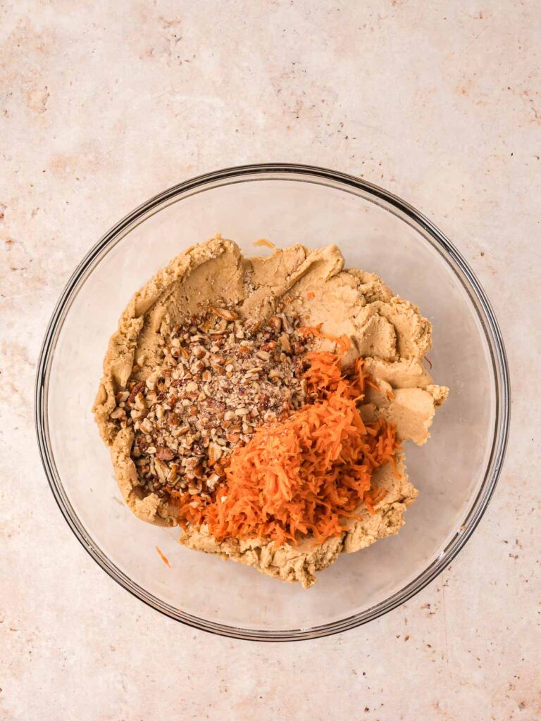 Carrot cake cookie dough mixed with shredded carrots and chopped pecans.