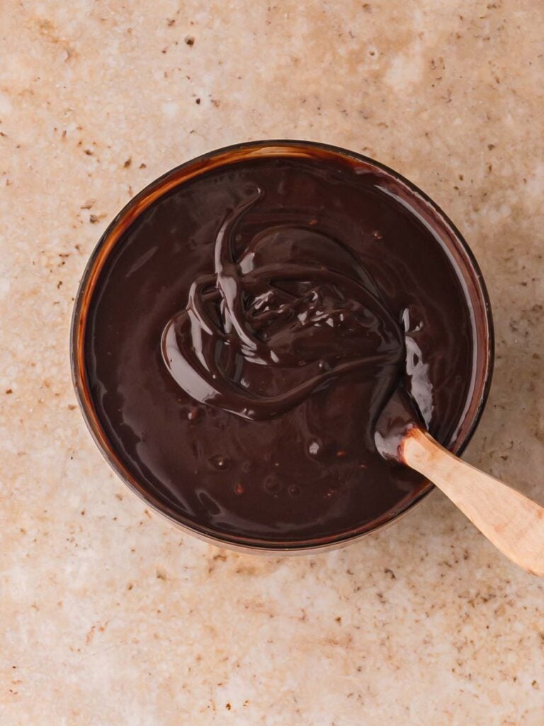 Chocolate ganache mixture being stirred in a bowl while making Chocolate Baileys Truffles.