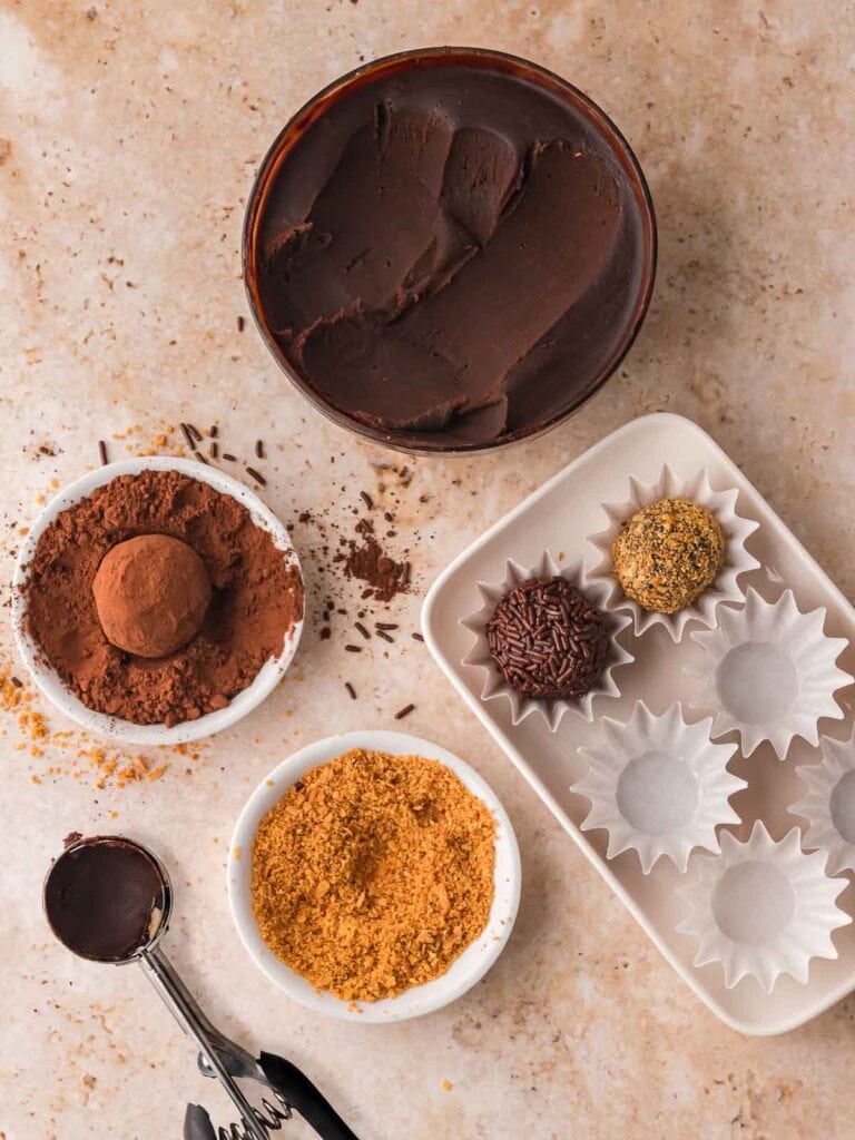 Rolling a chocolate truffle in cocoa powder for Chocolate Baileys Truffles.