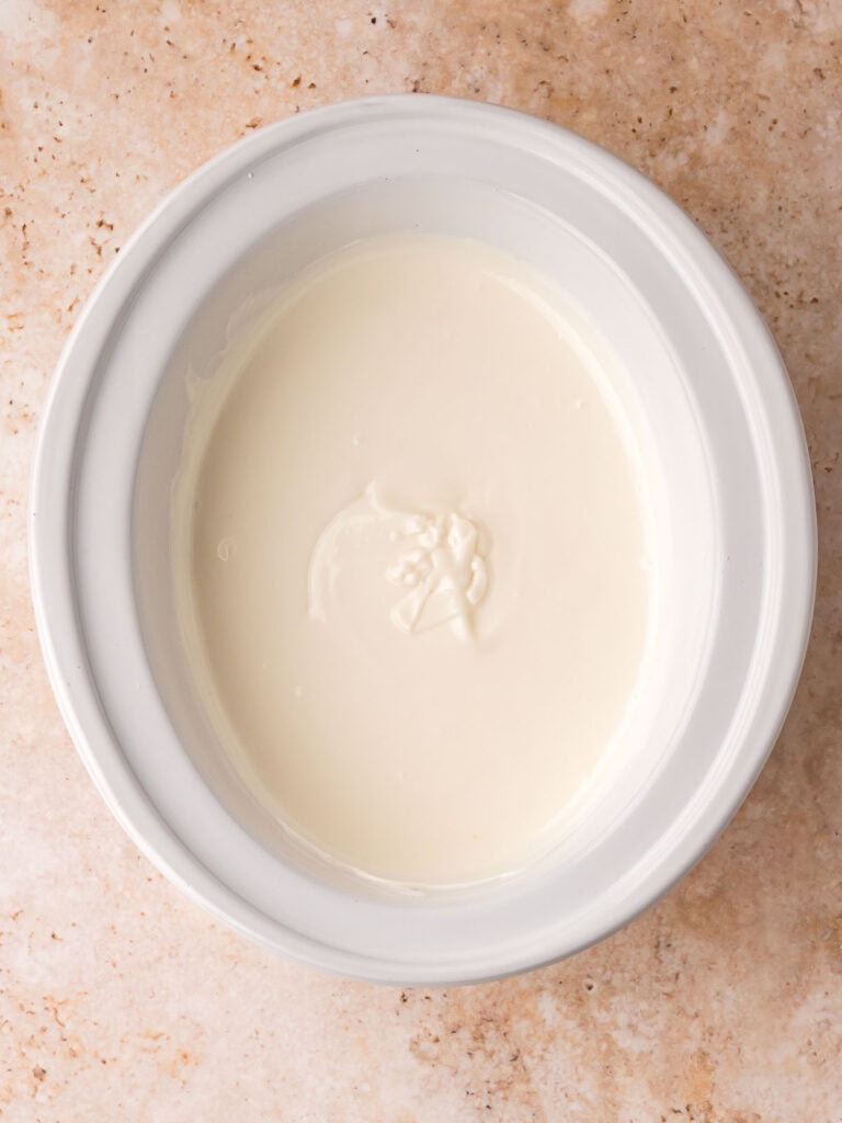 Smooth melted white chocolate in a slow cooker ready for adding mix ins.