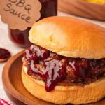 BBQ pulled beef sandwich on soft bun with homemade BBQ sauce on top.