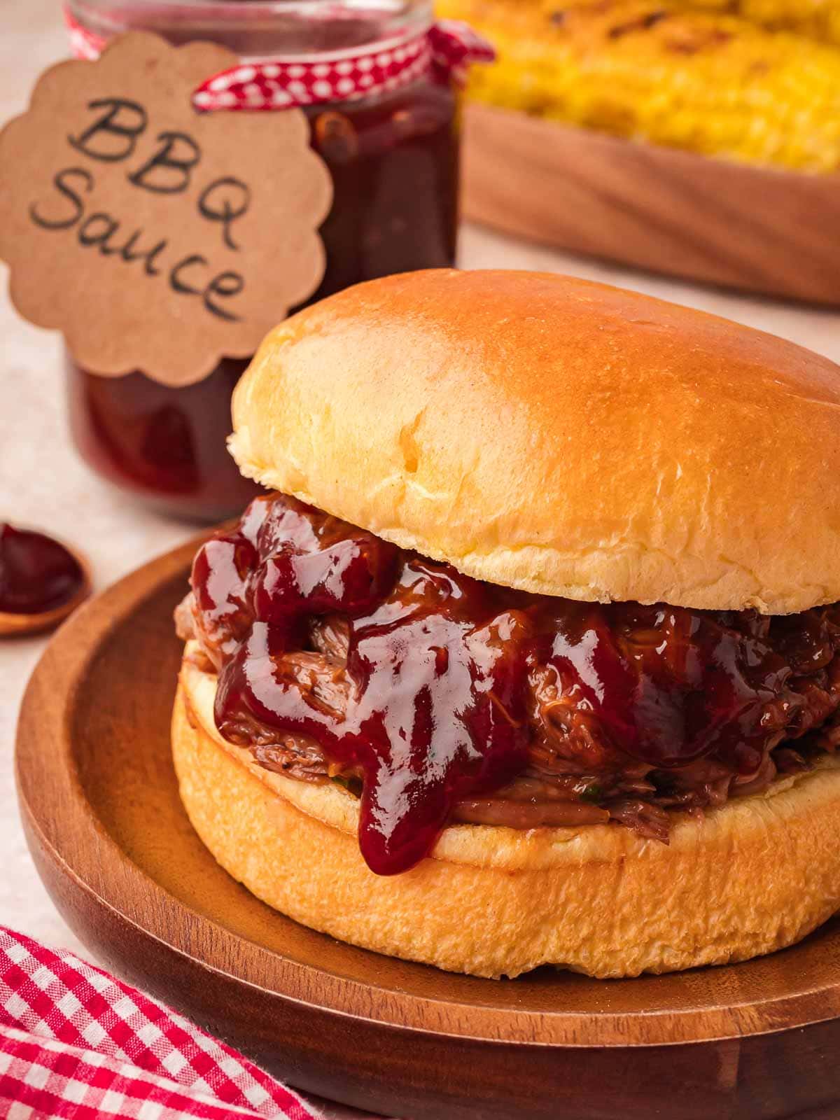 BBQ pulled beef sandwich on soft bun with homemade BBQ sauce on top.