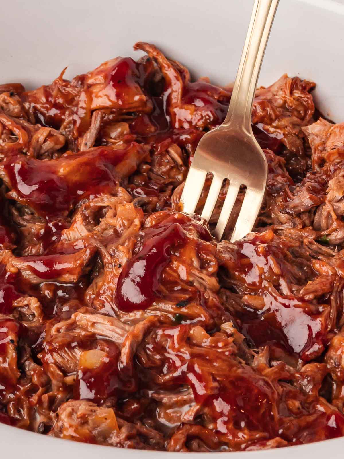 Shredded BBQ beef with homemade BBQ sauce and fork close up.