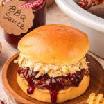 Slow cooker BBQ beef sandwich with coleslaw on brioche bun.