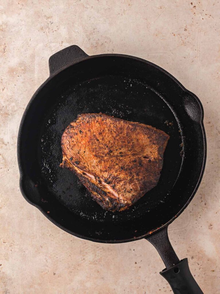 Chuck roast seared in cast iron skillet until browned.