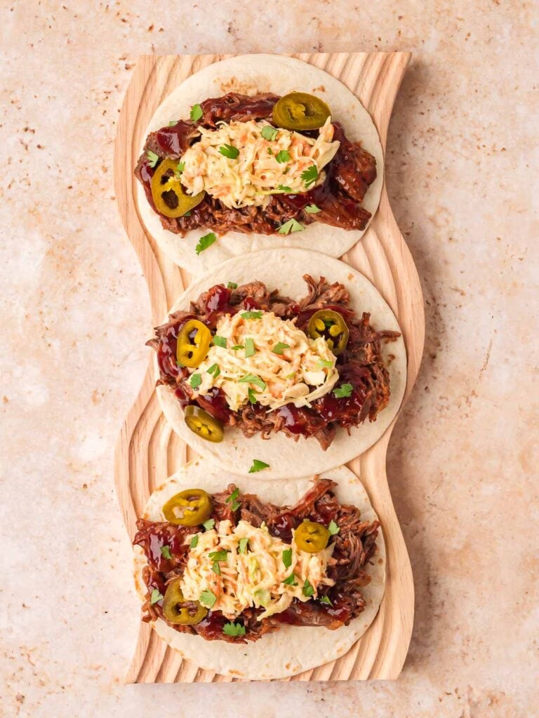 Filled tortillas with BBQ beef and topped with coleslaw, cilantro, and extra BBQ sauce if you like.