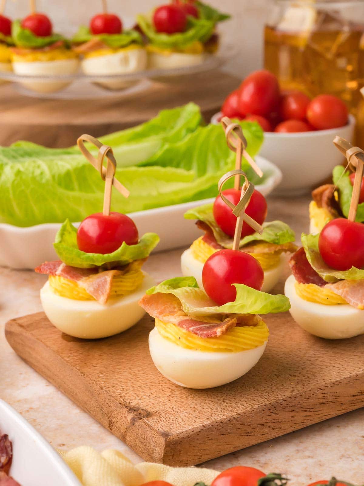 Easy BLT deviled eggs with bacon, romaine lettuce, and cherry tomatoes for summer parties.