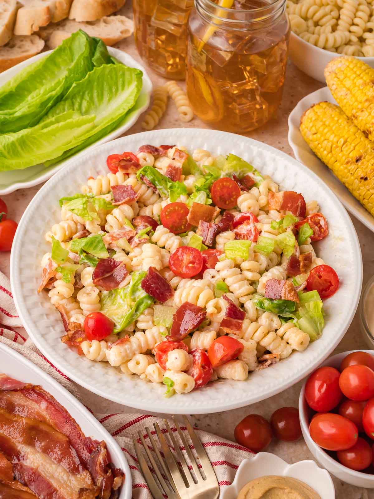 Easy BLT pasta salad served with bacon, cherry tomatoes, and lettuce for summer BBQs.