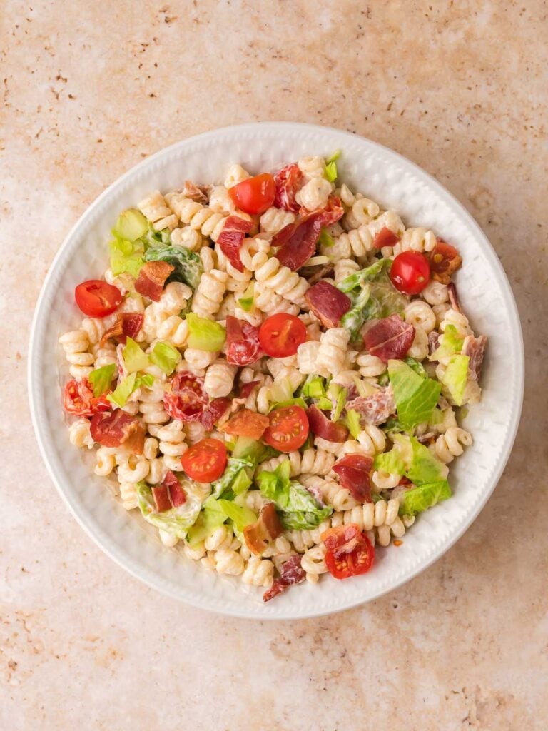 Creamy BLT pasta salad mixed with bacon, lettuce, and cherry tomatoes.