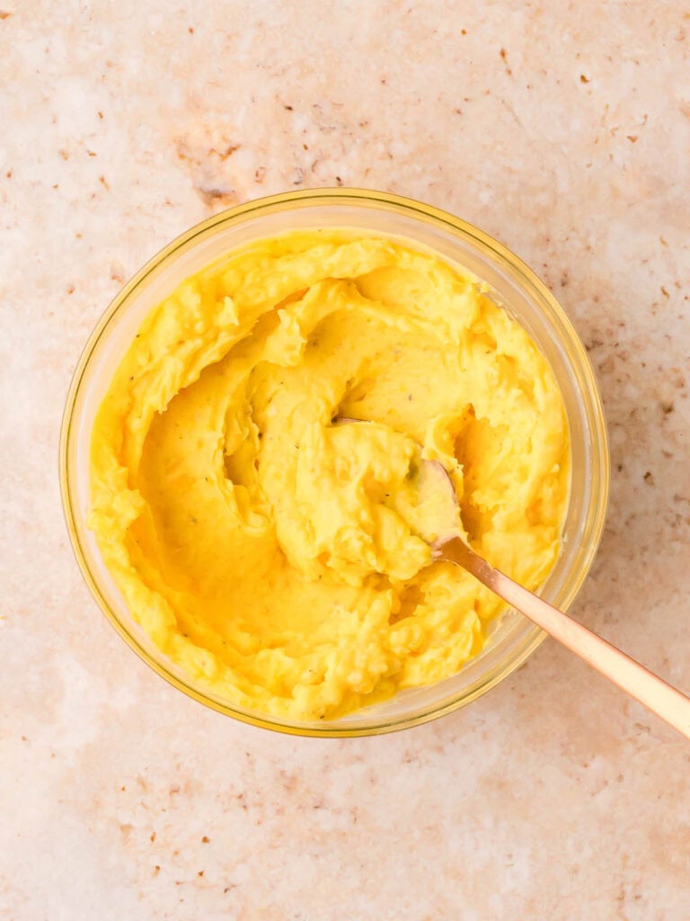 Creamy deviled egg filling mixed in a glass bowl.