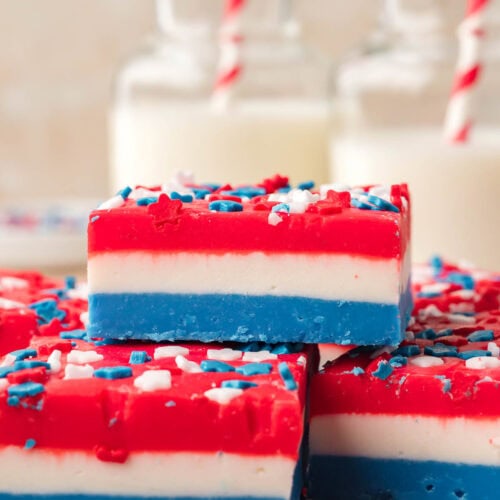 Close-up of patriotic layered fudge with red, white, and blue layers and star sprinkles on top.