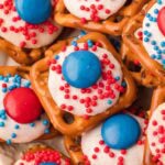 Close up of Red White and Blue Pretzel Bites topped with white chocolate, red and blue M&Ms, and sprinkles.
