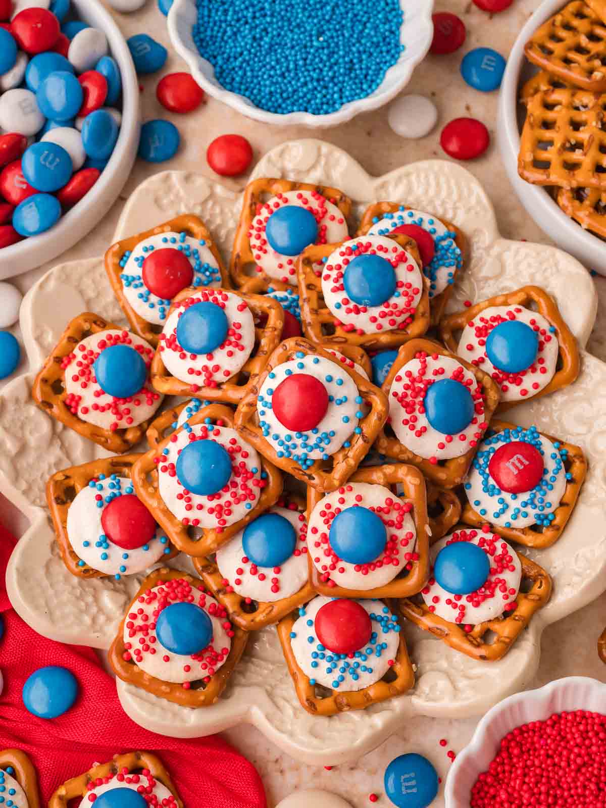 Pile of Red White and Blue Pretzel Bites on a serving tray with patriotic sprinkles and candy.