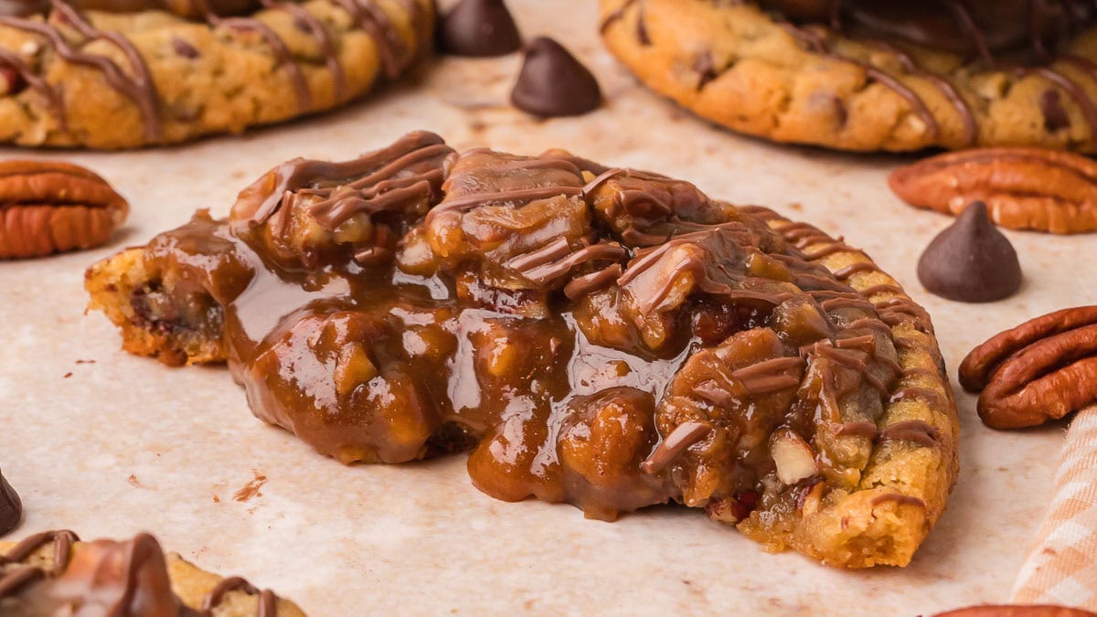 Pecan pie cookie broken in half showing the gooey pecan filling by Tessie's Table.