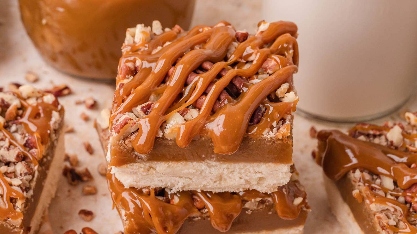 Close up of salted caramel pecan bars with caramel drizzle and toasted pecans by Tessie's Table.