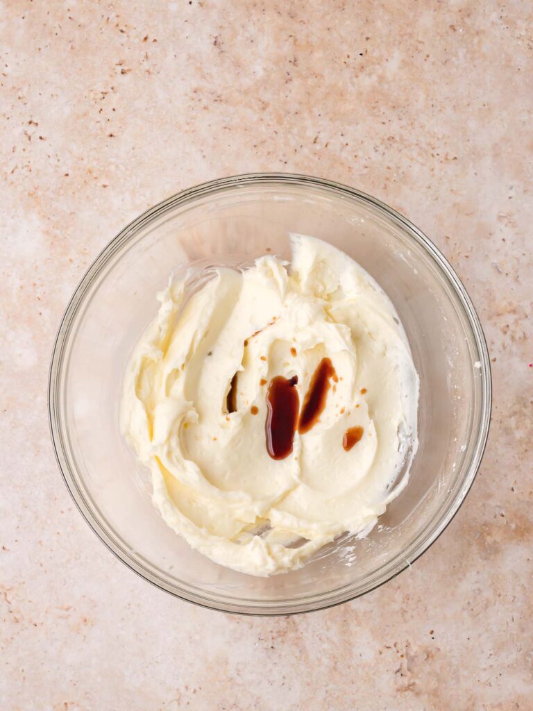 Butter and powdered sugar creamed in a glass bowl with vanilla poured on top for salted caramel pecan bars by Tessie's Table.