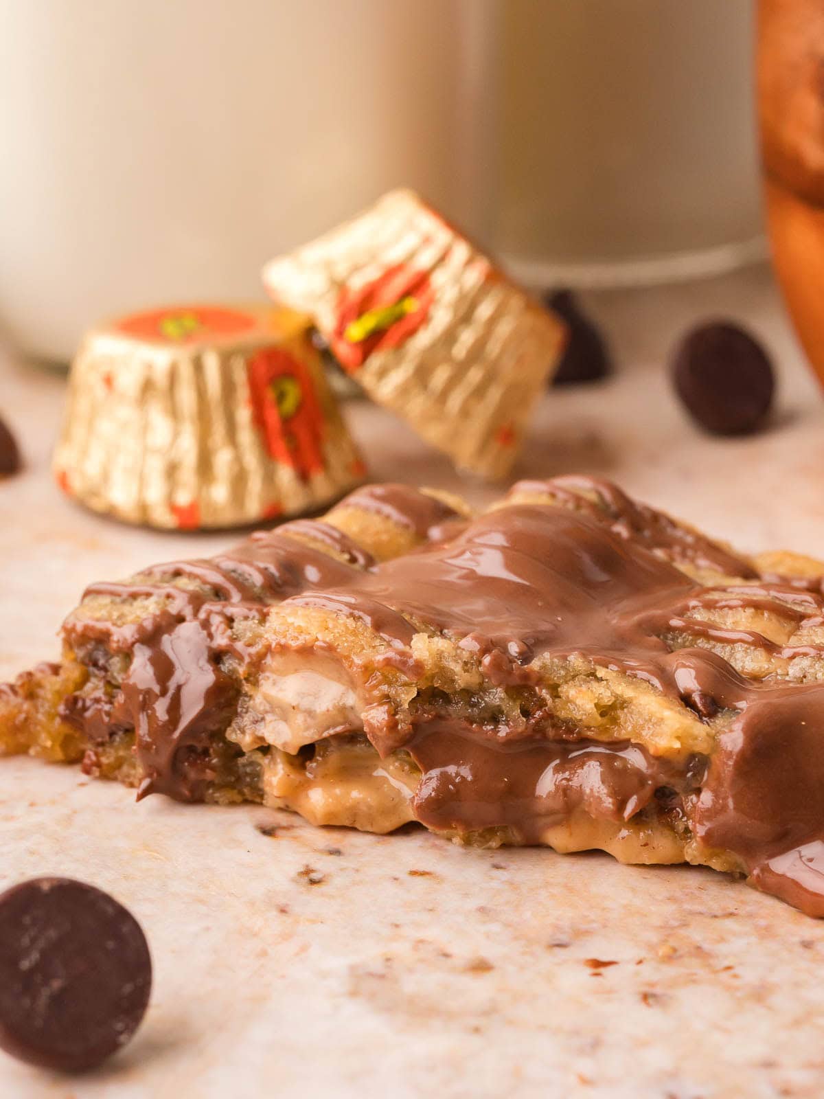 Nutella stuffed Reese's cookie broken open to show the Nutella and peanut butter center with Reese's cups behind it by Tessie's Table.