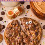 Nutella stuffed monster cookie broken in half showing the gooey Nutella and peanut butter center, with candy eyes, Halloween sprinkles and Reese's cups around it by Tessie's Table.