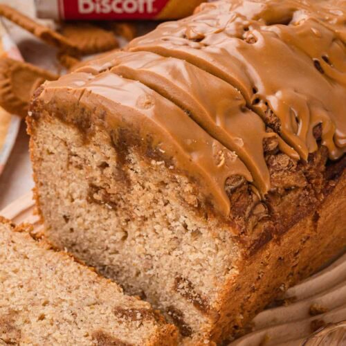 Cut end of a Biscoff banana bread loaf showing cookie butter swirls through a soft crumb and a glossy Biscoff topping by Tessie's Table.