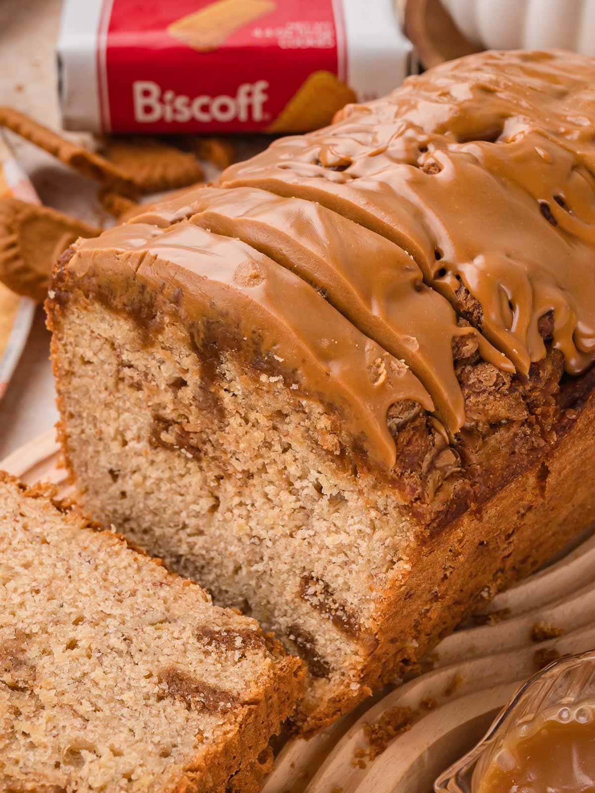 Cut end of a Biscoff banana bread loaf showing cookie butter swirls through a soft crumb and a glossy Biscoff topping by Tessie's Table.