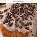 Loaf of Oreo banana bread topped with a cookies and cream glaze and chopped Oreo cookies.
