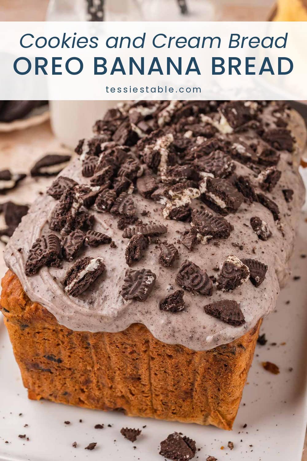 Loaf of Oreo banana bread topped with a cookies and cream glaze and chopped Oreo cookies.